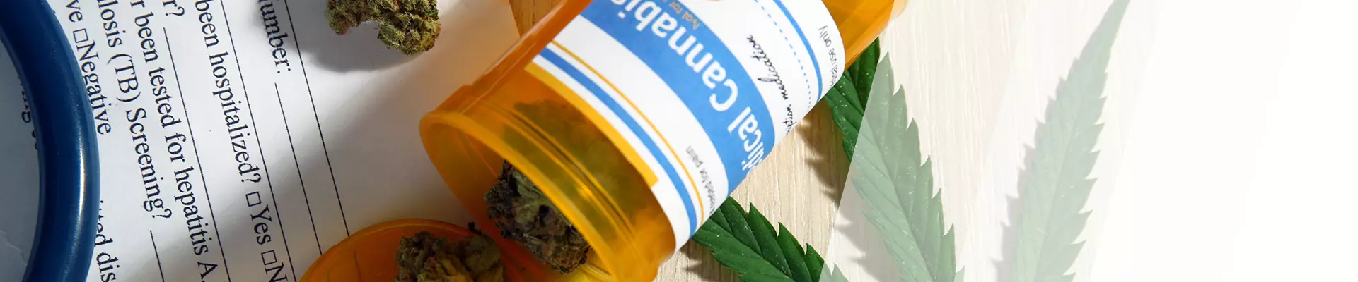 Eine Dose mit Cannabis-Tabletten liegt auf einem Zettel, daneben ein Cannabisblatt